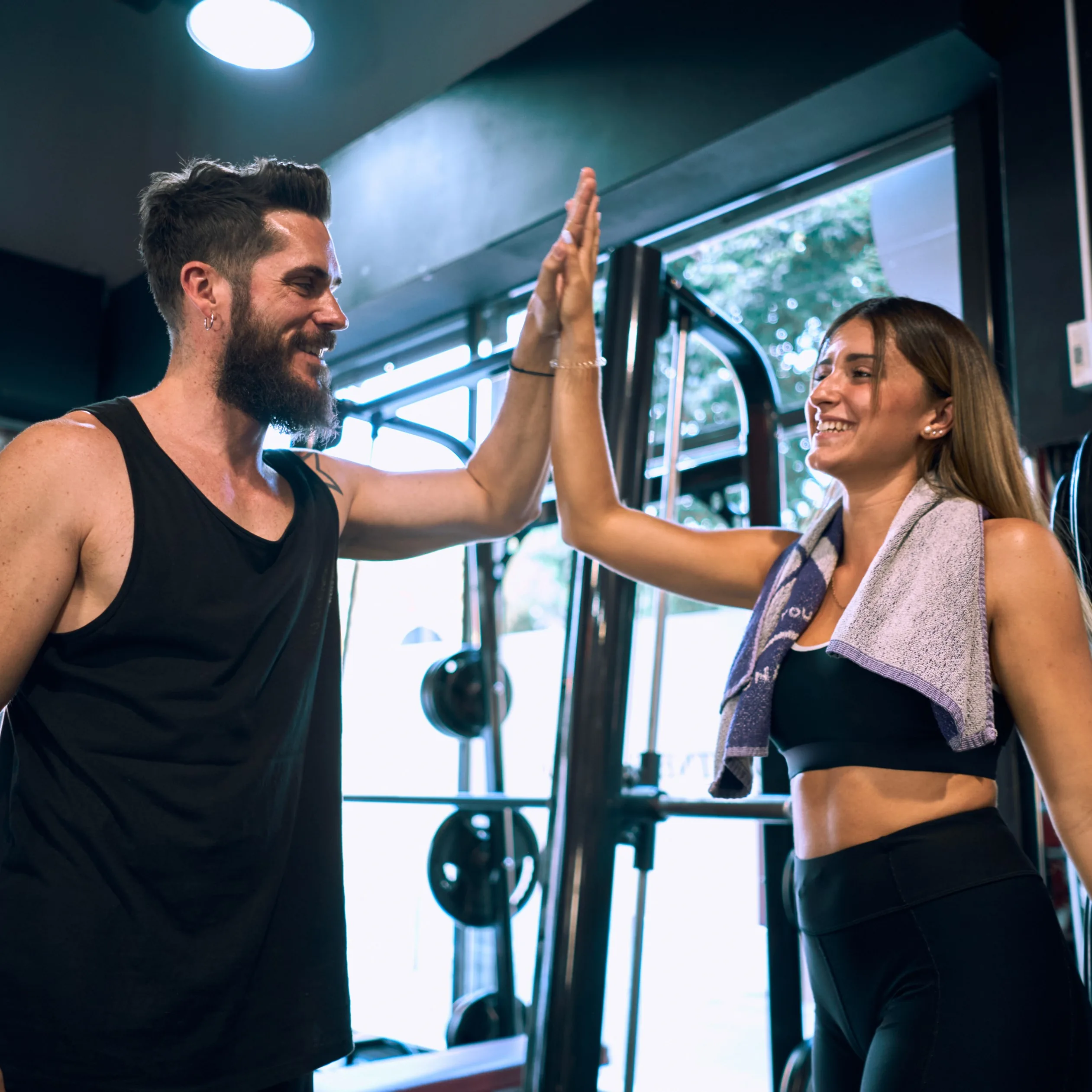 Ein Mann und eine Frau im Gym geben sich glücklich ein Highfive.